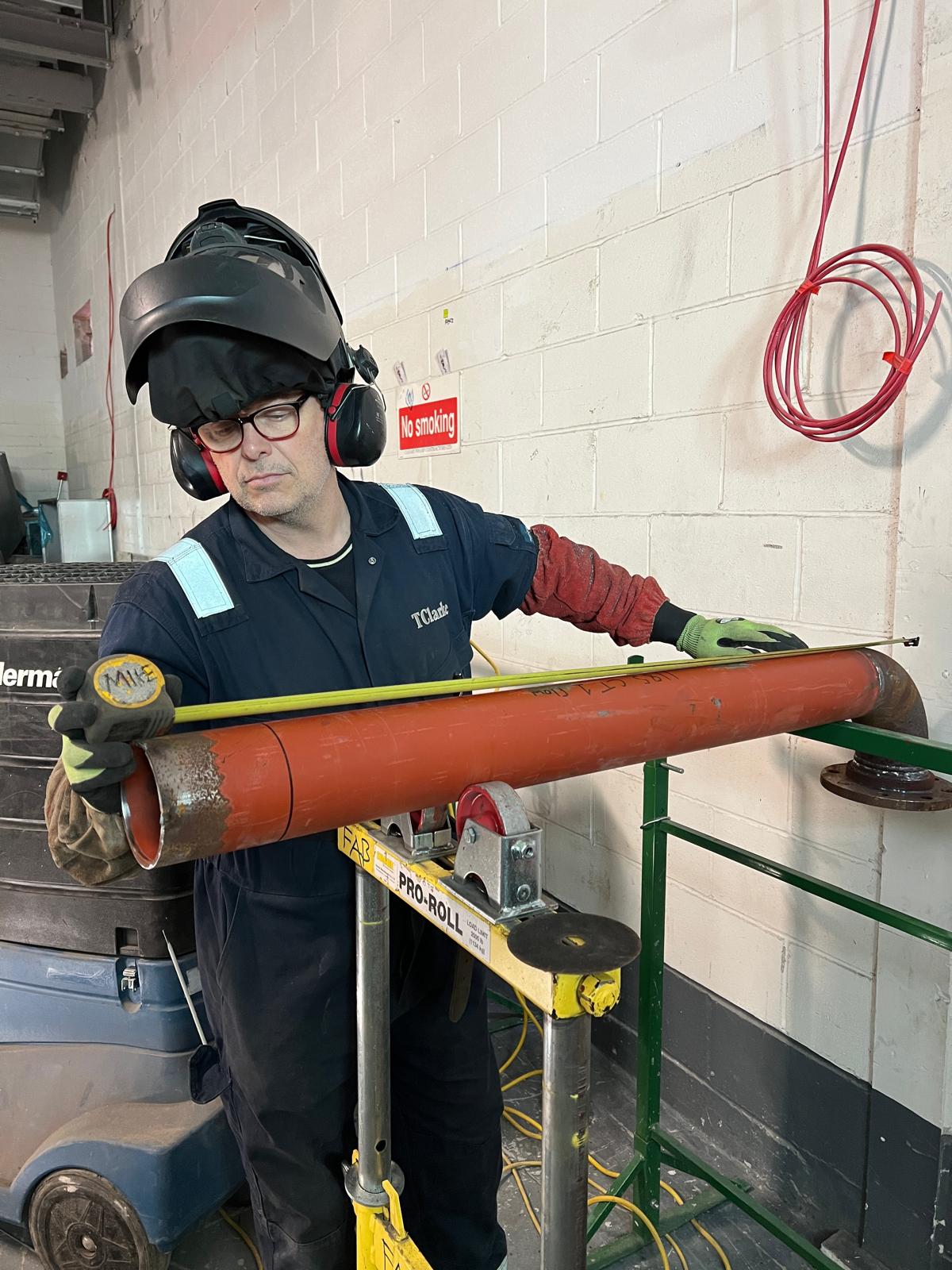 Mike laying out a pipe spool on rollers