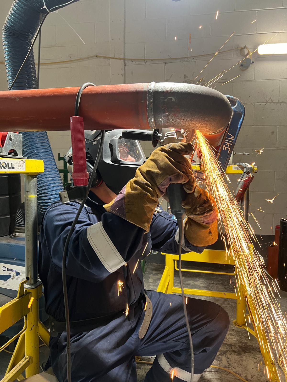 Sparks flying from angle grinder cleaning a weld
